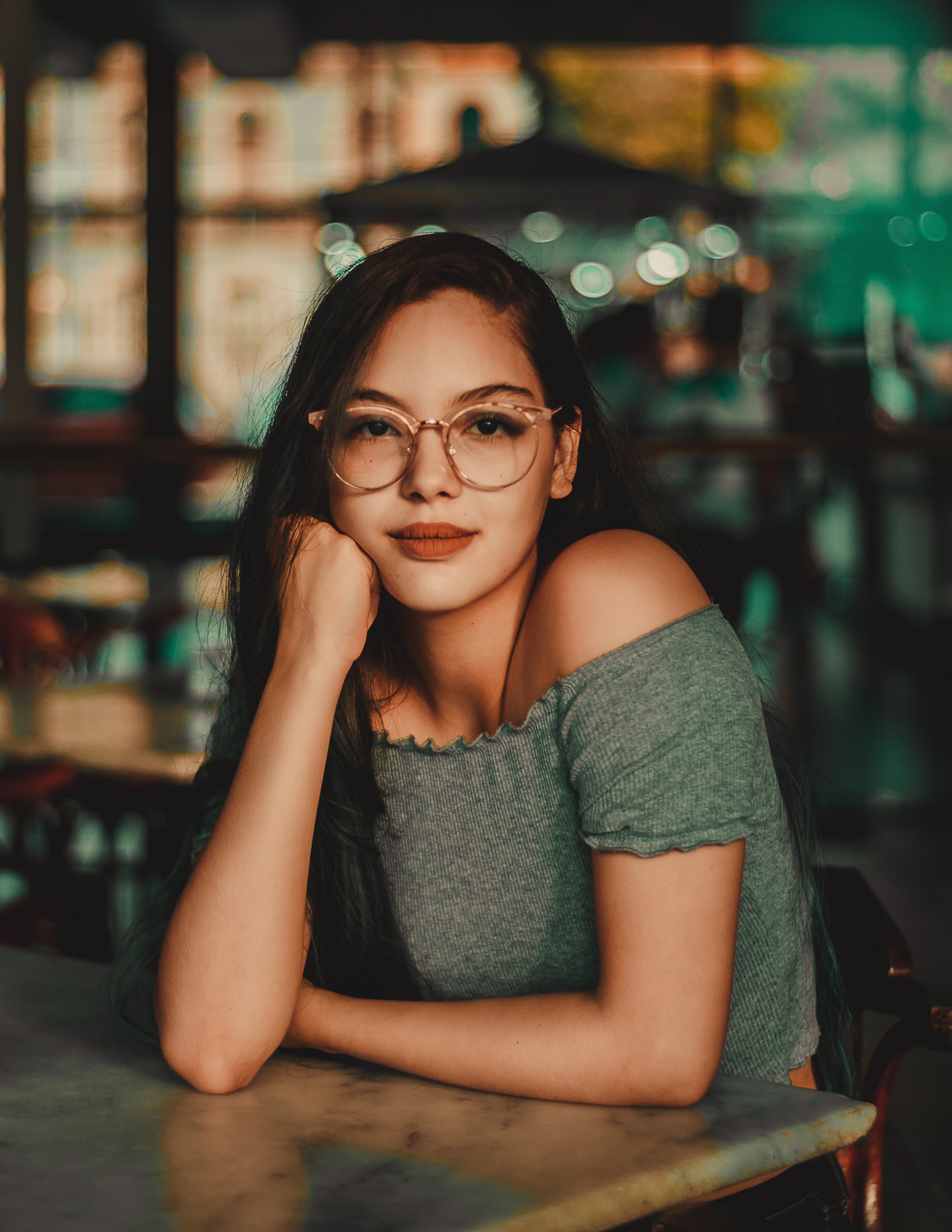 woman-wearing-eyeglasses-sitting-beside-table-1998865